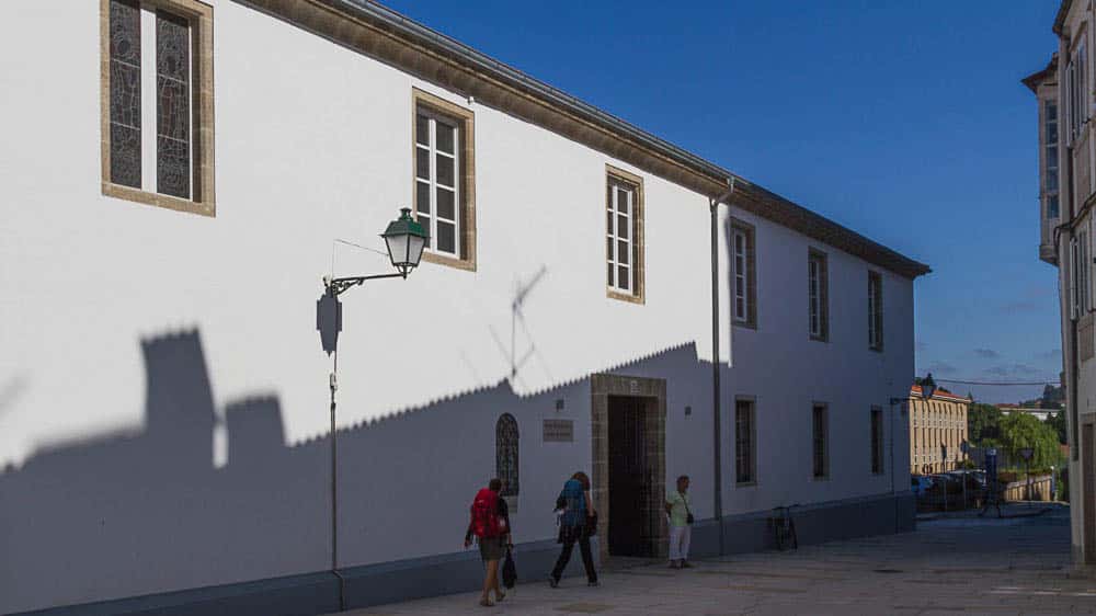 Weiß gestrichenes, langgezogenes Gebäude in Santiago, in dem jetzt das Pilgerbüro untergebracht ist
