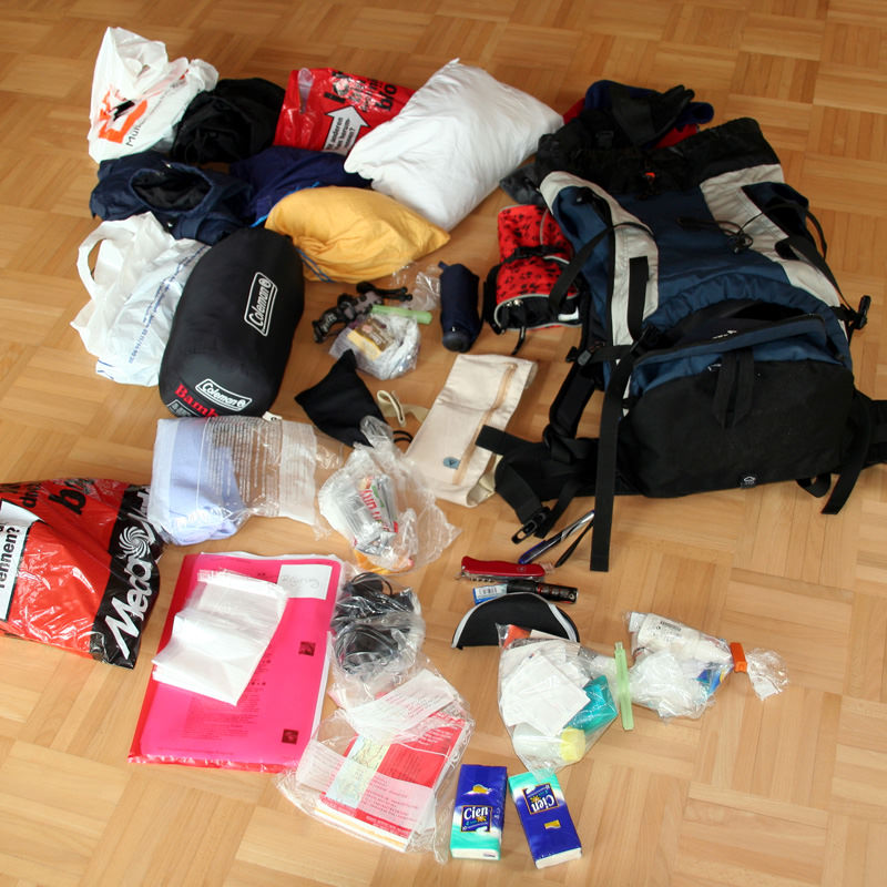 Schuhe, Kulturbeutel, Kleidung, Unterlagen, alles ordentlich in Tüten, auf dem Boden bevor es in den Rucksack kommt